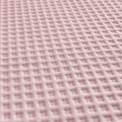 Close-up of a textured pink fabric with a grid pattern
